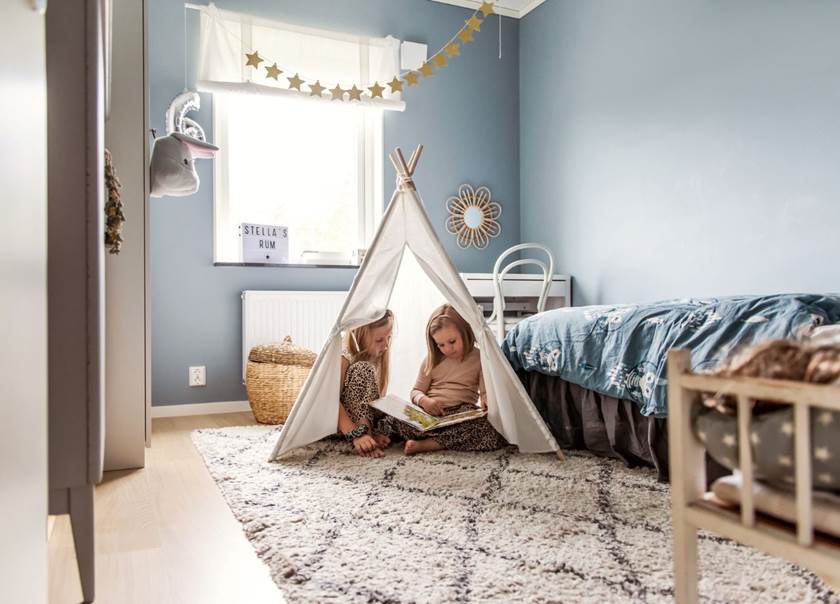 Two sisters in bedroom playing in a tent