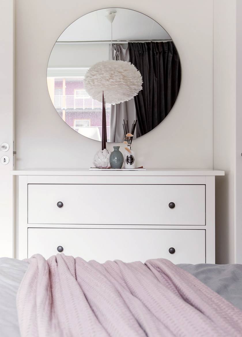 White chest of draws with round mirror above