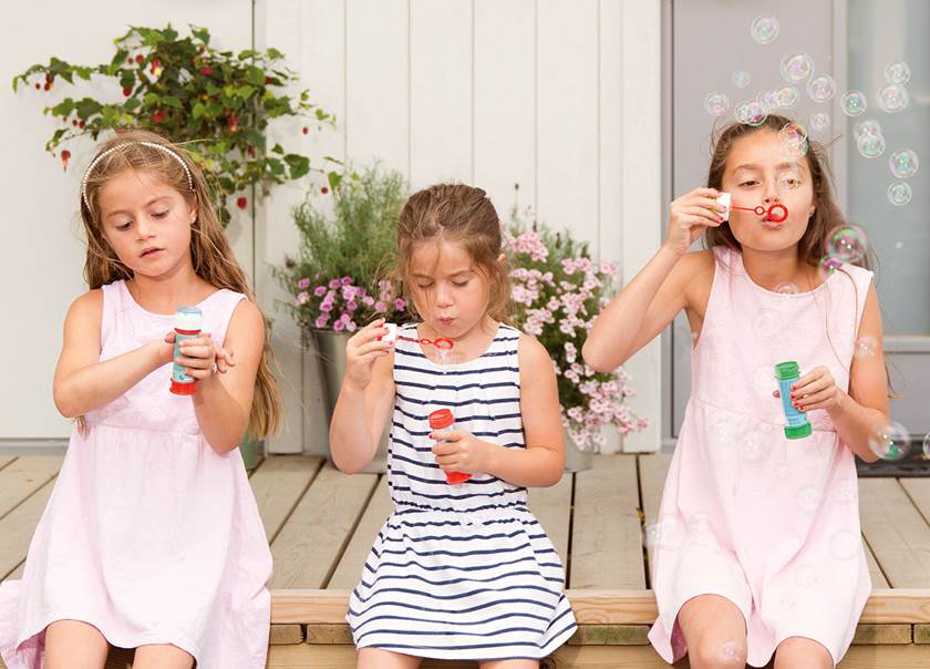 Three children sat blowing bubbles