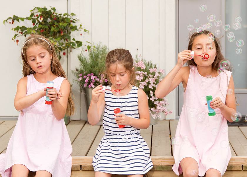 Three children sat blowing bubbles.