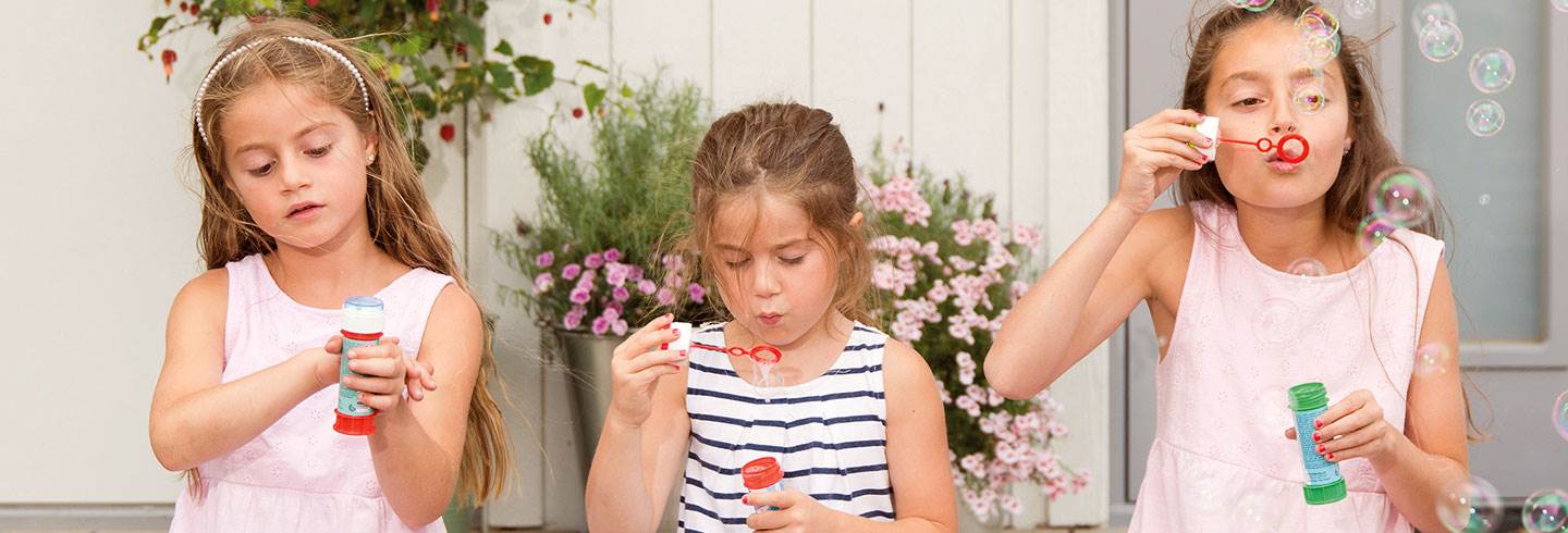 Three children sat blowing bubbles