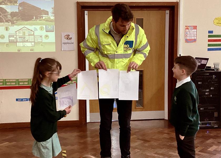 BoKlok team member in high vis showing school children plans