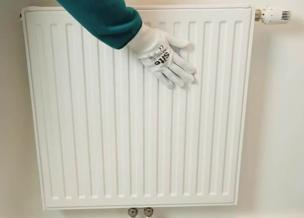 Hand with glove holding on radiator.