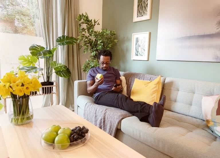 Man sat on sofa looking at phone 