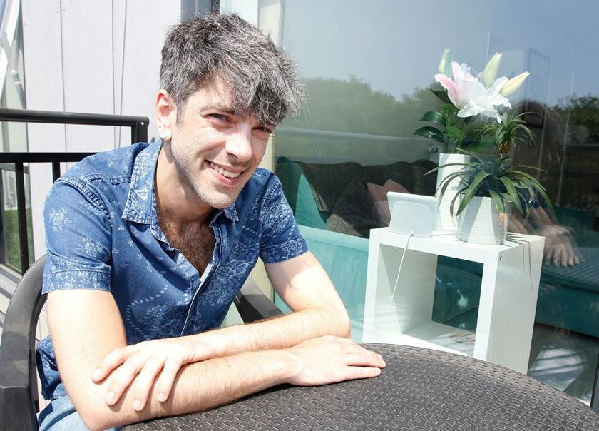 Man sat at garden table on balcony Man sat at garden table on balcony