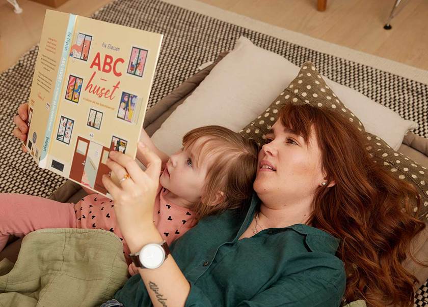 A lady reading a story to her daughter
