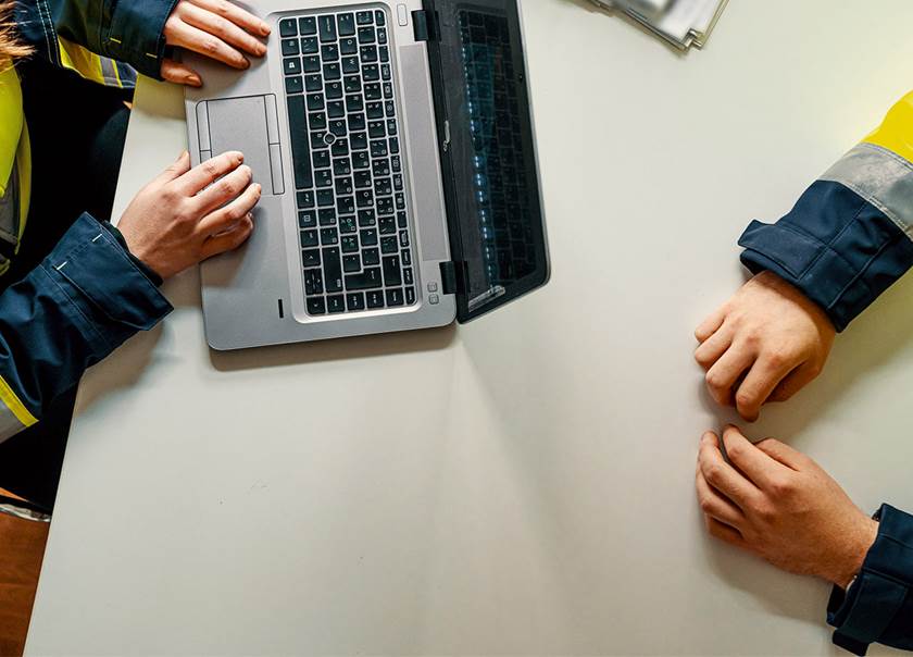 Man and woman at a desk with a laptop.