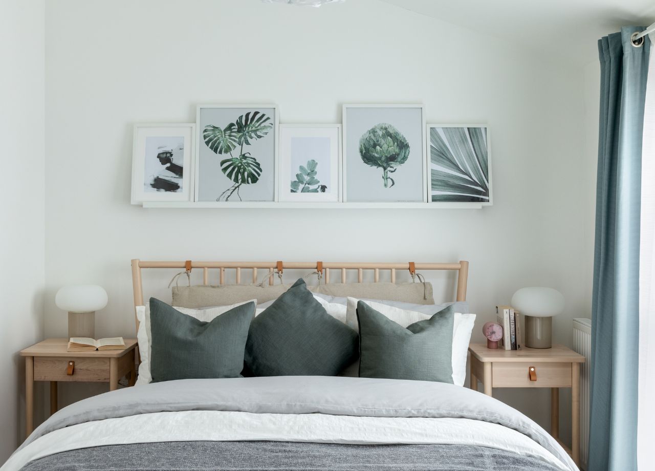 Double bed with grey bed linen and wooden nightstands.