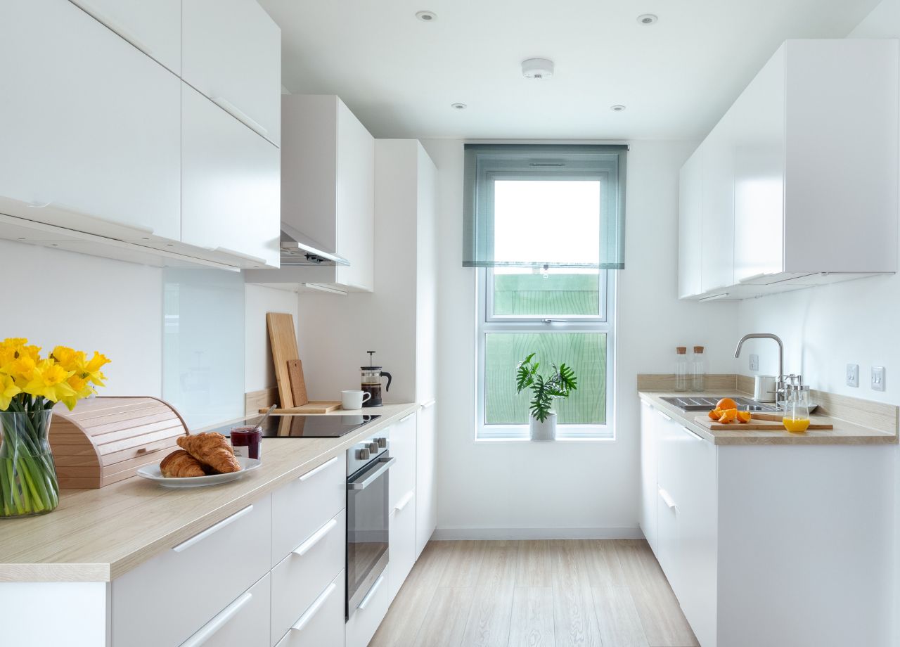 Internal kitchen with white cabinets and wooden kitchen counters..